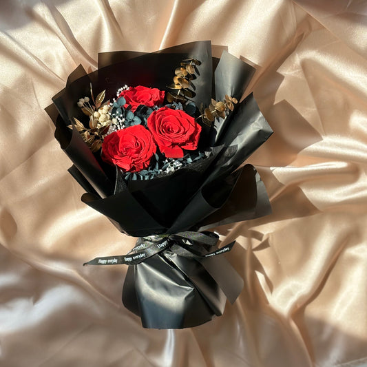 three red roses wrapped in sleek black paper. Express love and passion with these preserved beauties. Perfect for any occasion.