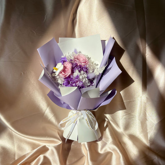 two stunning pink roses wrapped in lavender paper. These roses exude grace and elegance, making them an ideal gift for expressing love and appreciation.